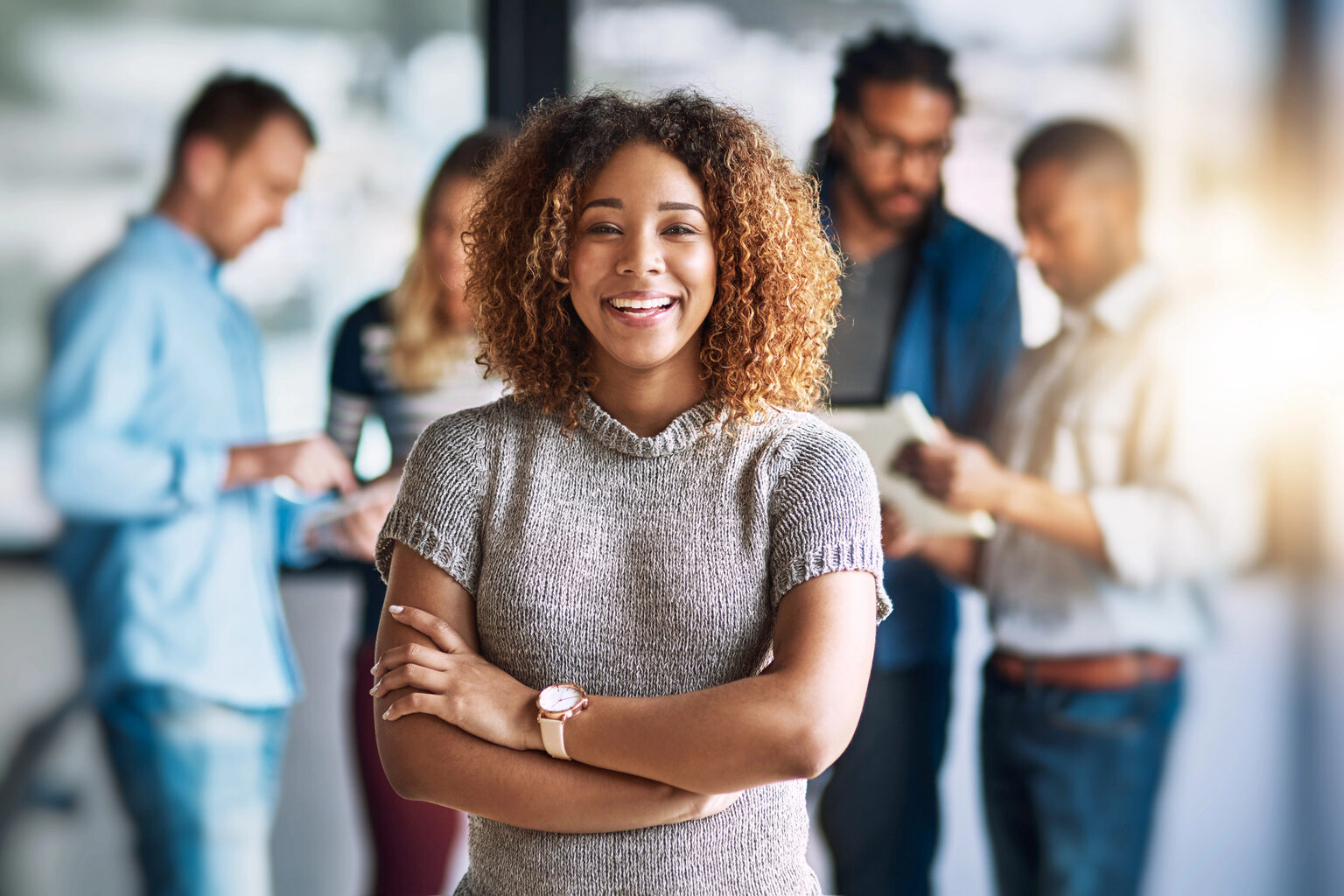 Smiling business owner with her team behind her